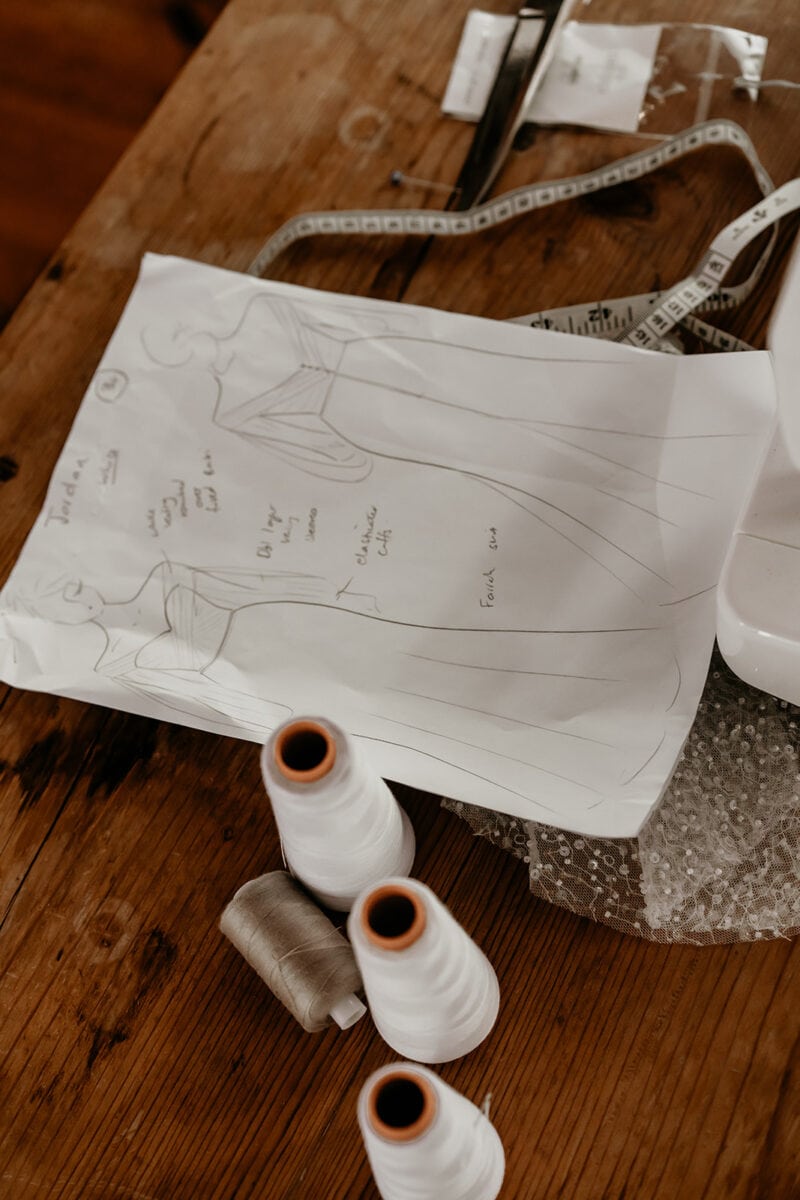 dressmakers bridal dress sketch on paper with scissors on a table